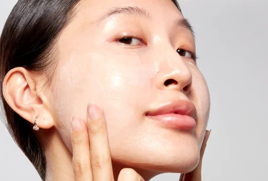 Woman applying seaweed night cream to her face.  