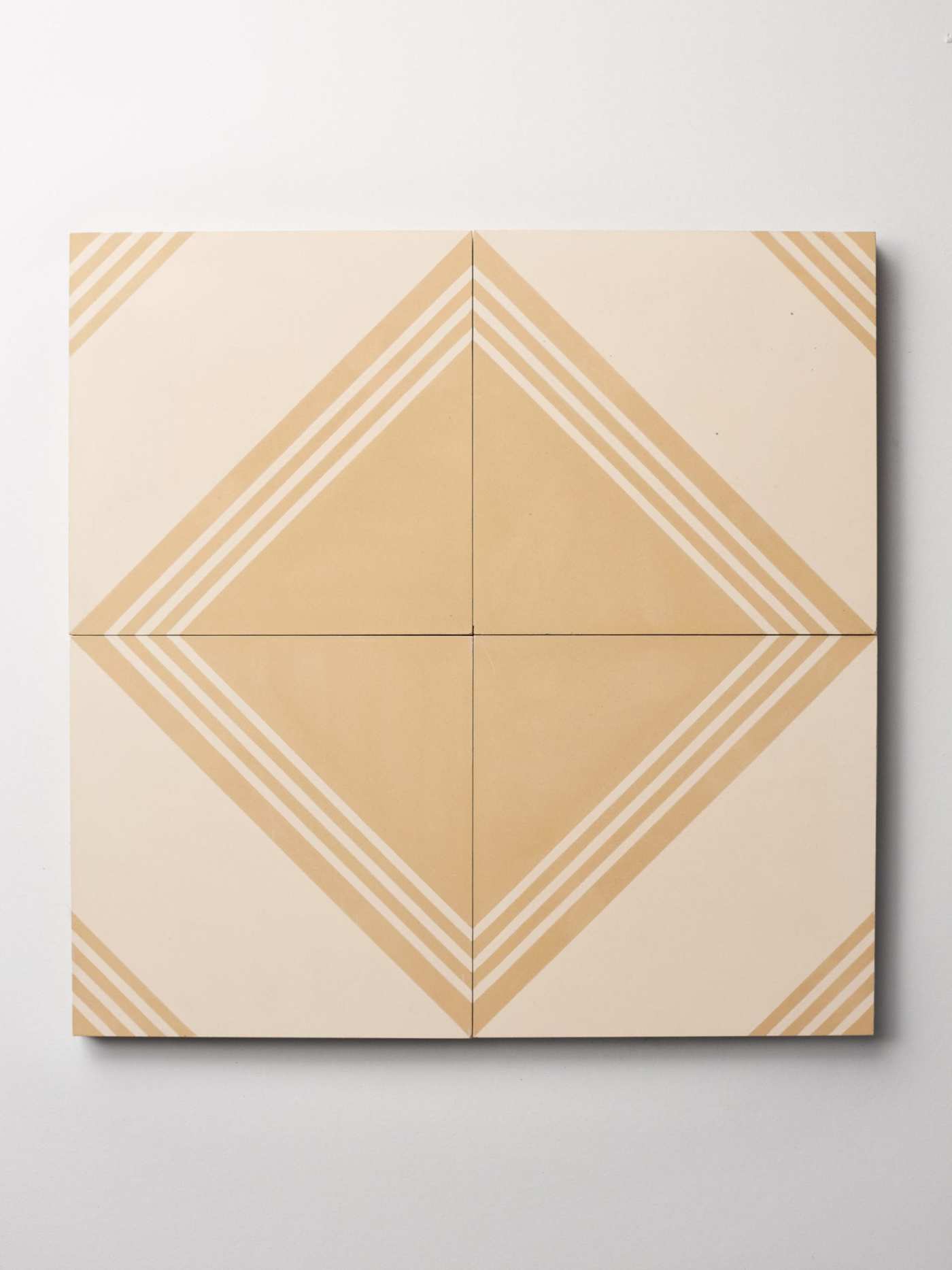 four beige and white tiles on a white surface.
