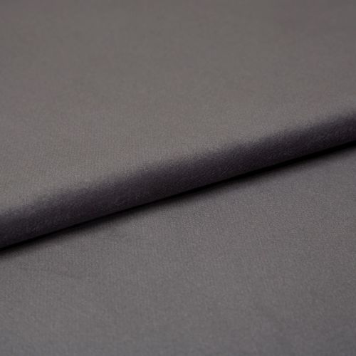 Matte charcoal-gray fabric (object) folded into an overlapping layer, revealing fine soft texture (action); close-up studio shot with even, diffuse lighting and a neutral backdrop (context).