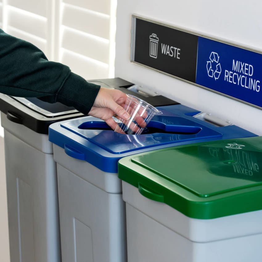 wall hanging recycling station showing a person depositing an empty plastic cup