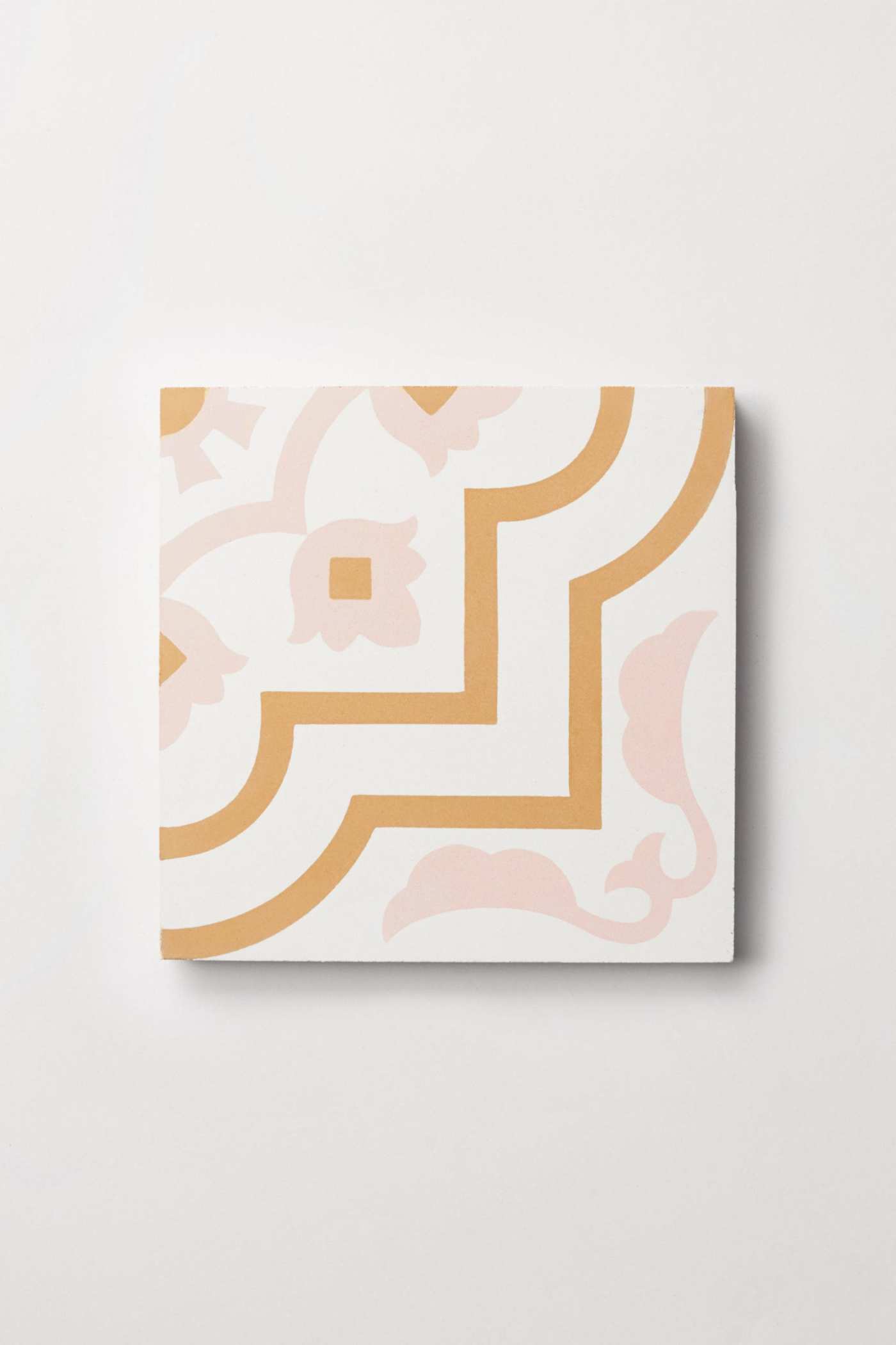 a white tile with a pink and gold design.