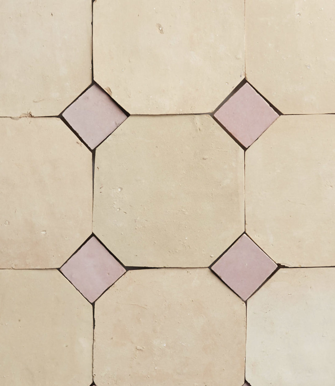 a close up of a tile with pink and beige squares.