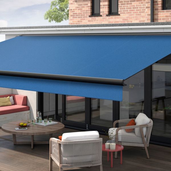 Blue retractable fabric awning with black front bar, fully extended over sliding glass doors, shading a modern outdoor patio with wicker chairs, low wooden table, brick wall and daylight.