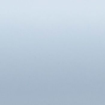 Pale blue-gray gradient surface; uniformly lit and featureless; appears as a smooth wall or sky under soft diffuse lighting with no discernible objects or depth cues.