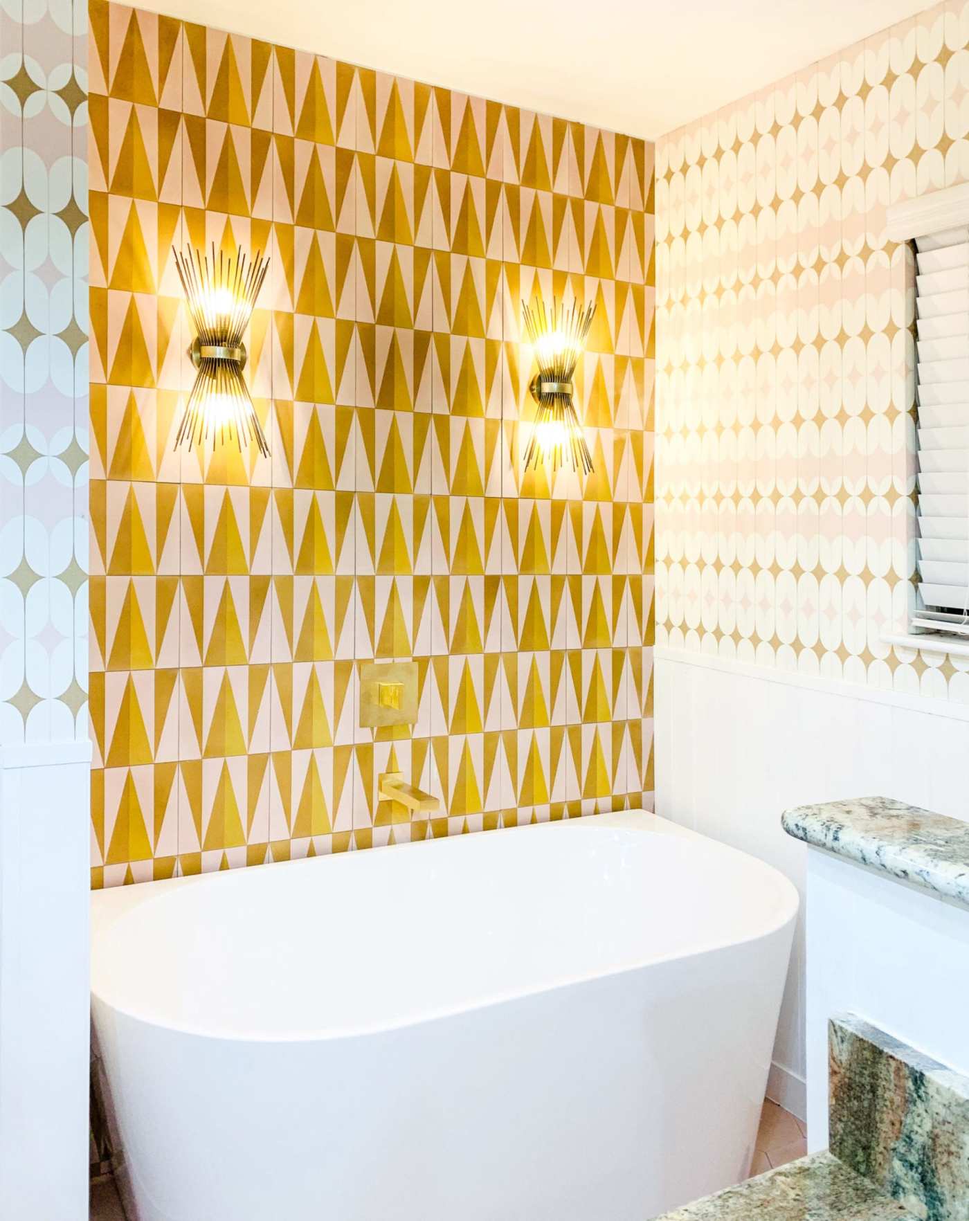 a bathroom with a bathtub and white and gold tiled walls.