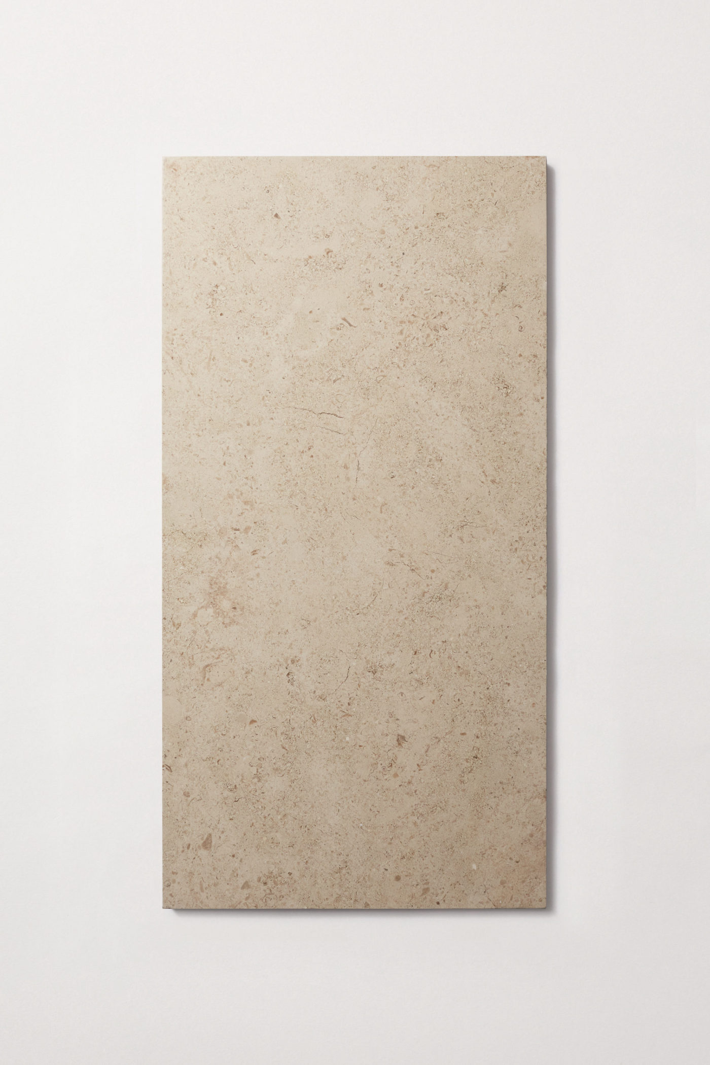 a beige limestone tile on a white surface.