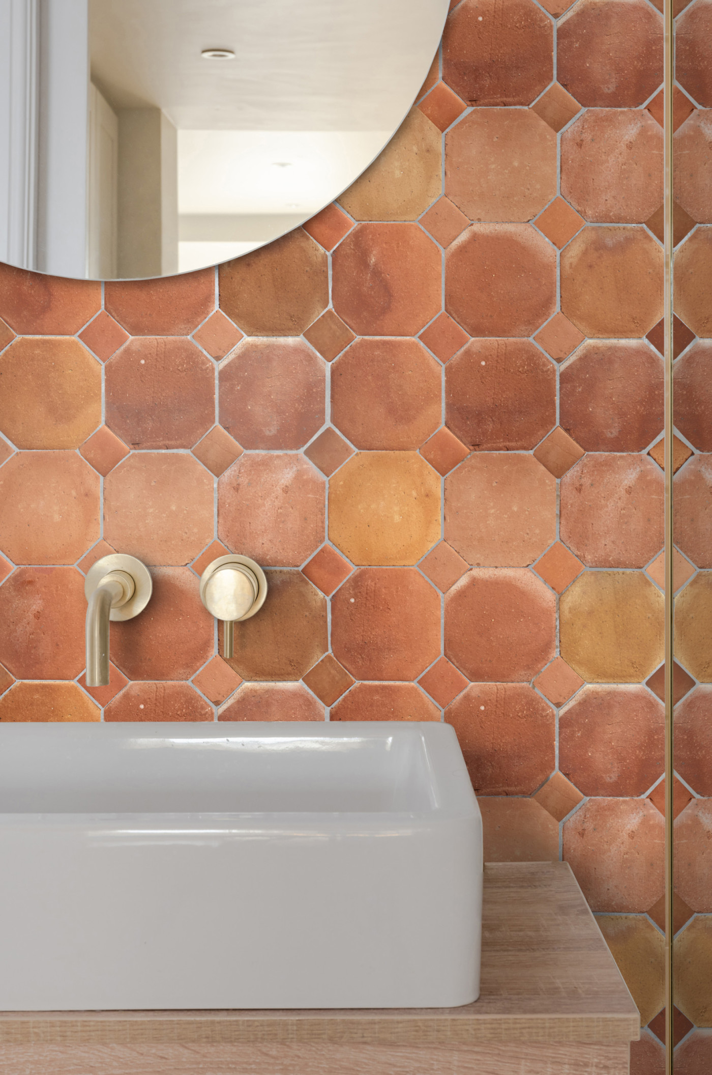 a bathroom with a tiled wall and a sink.