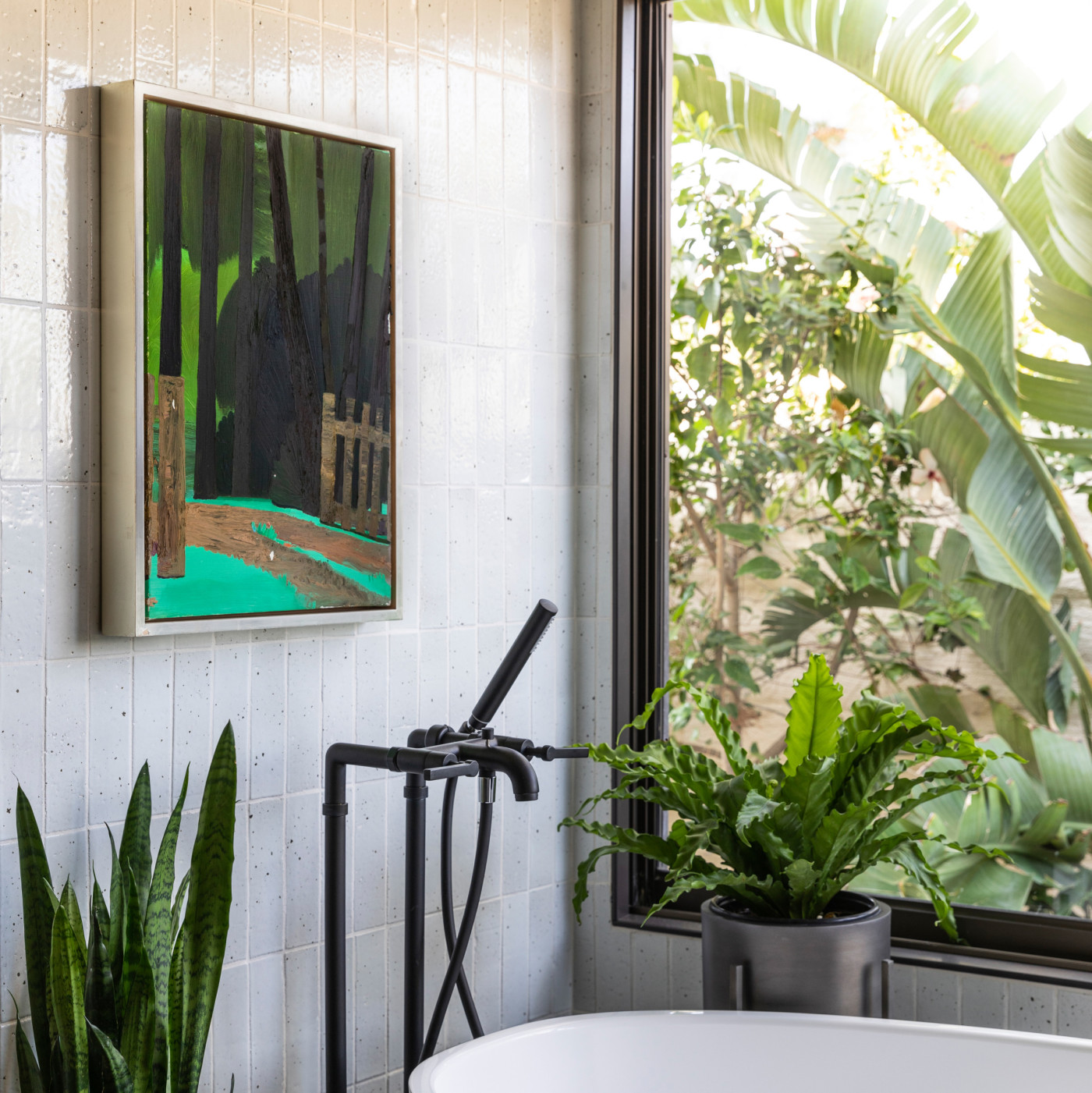 a bathroom with a bathtub and a painting on the wall.