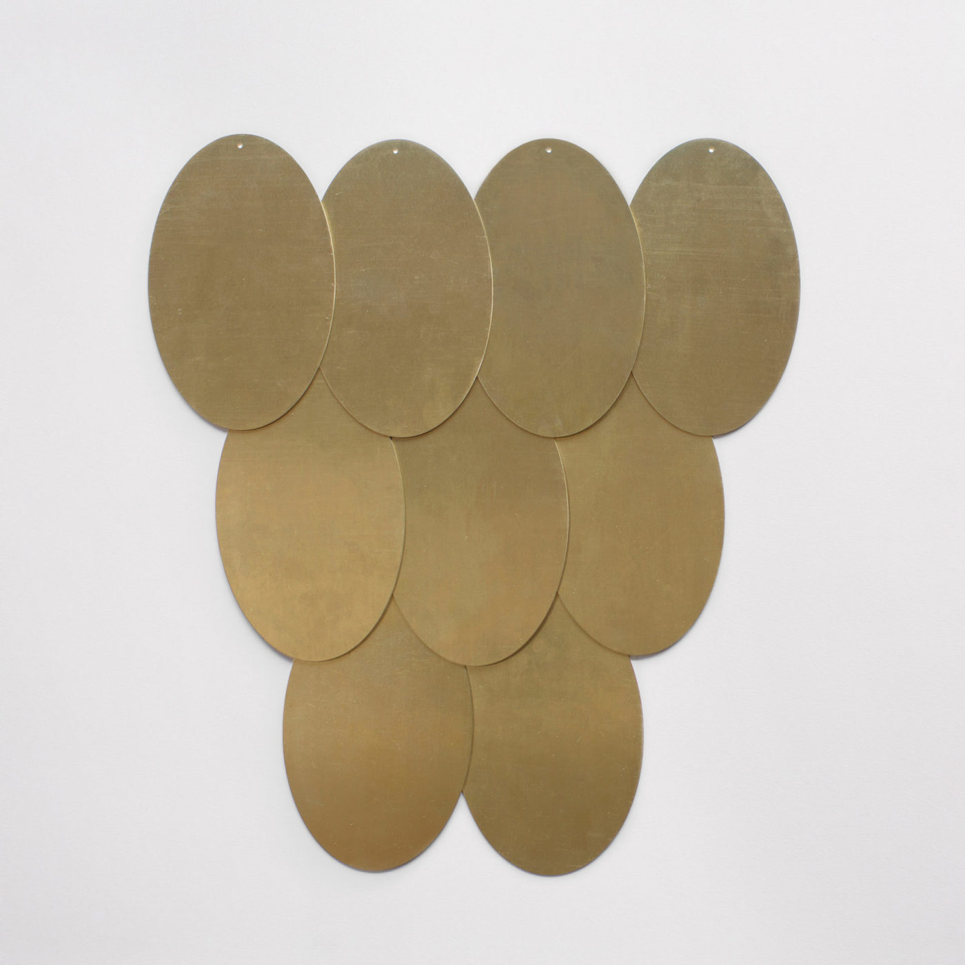 a group of brass circles hanging on a wall.