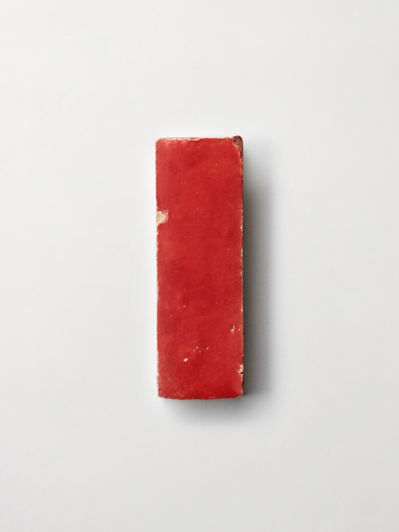 a red rectangular tile on a white background.