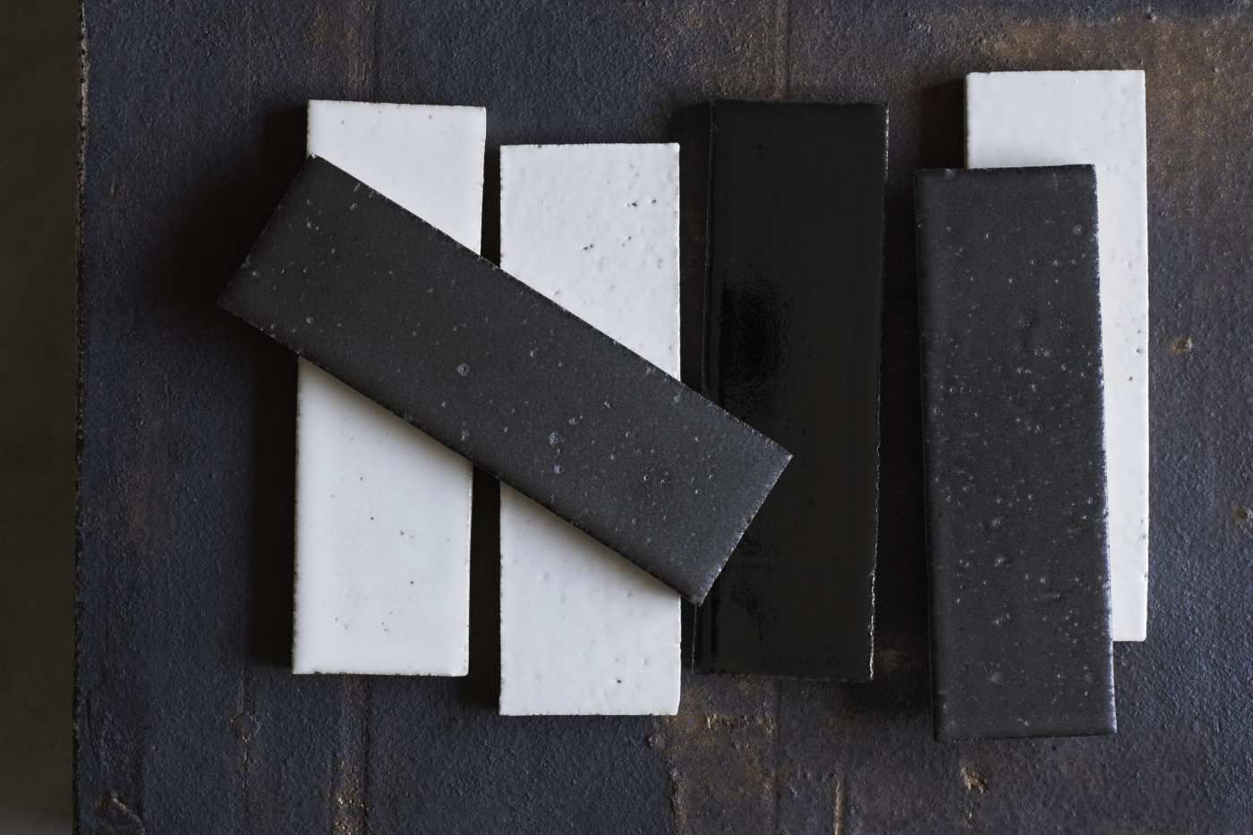 a group of black and white tiles on a wooden surface.