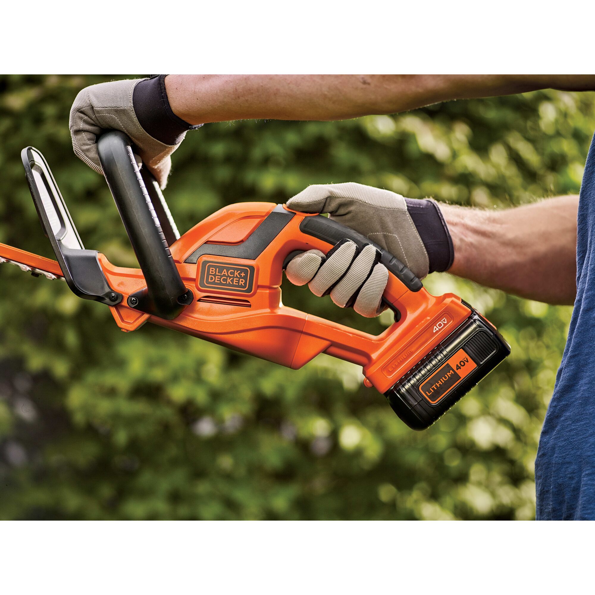 Close-up of man holding 22 Inch 40 Volt Max Hedge Trimmer.