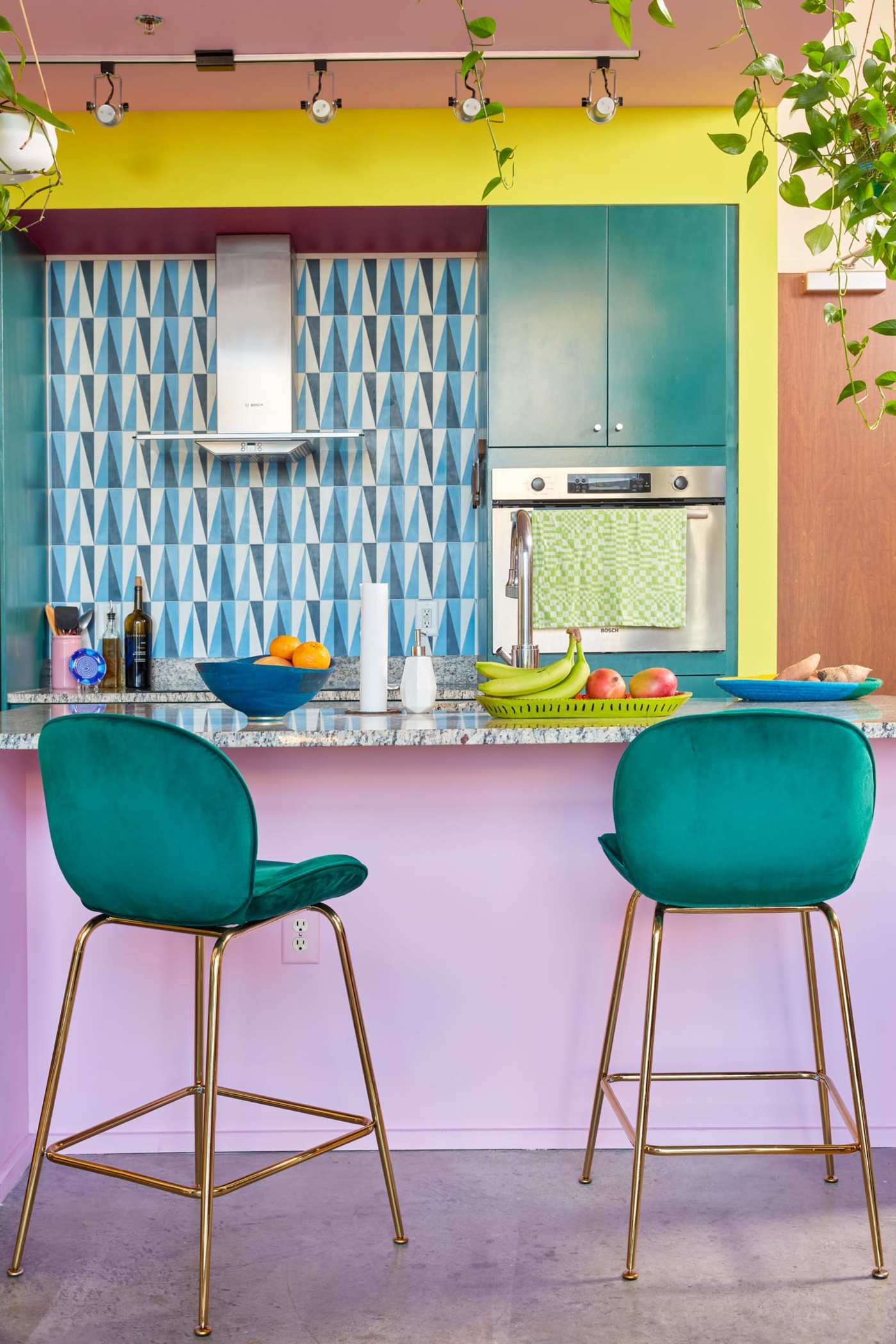 a kitchen with colorful tile walls and chairs.