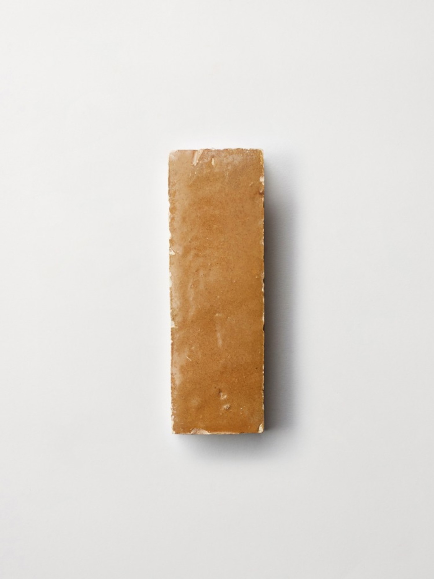 a piece of brown tile on a white background.