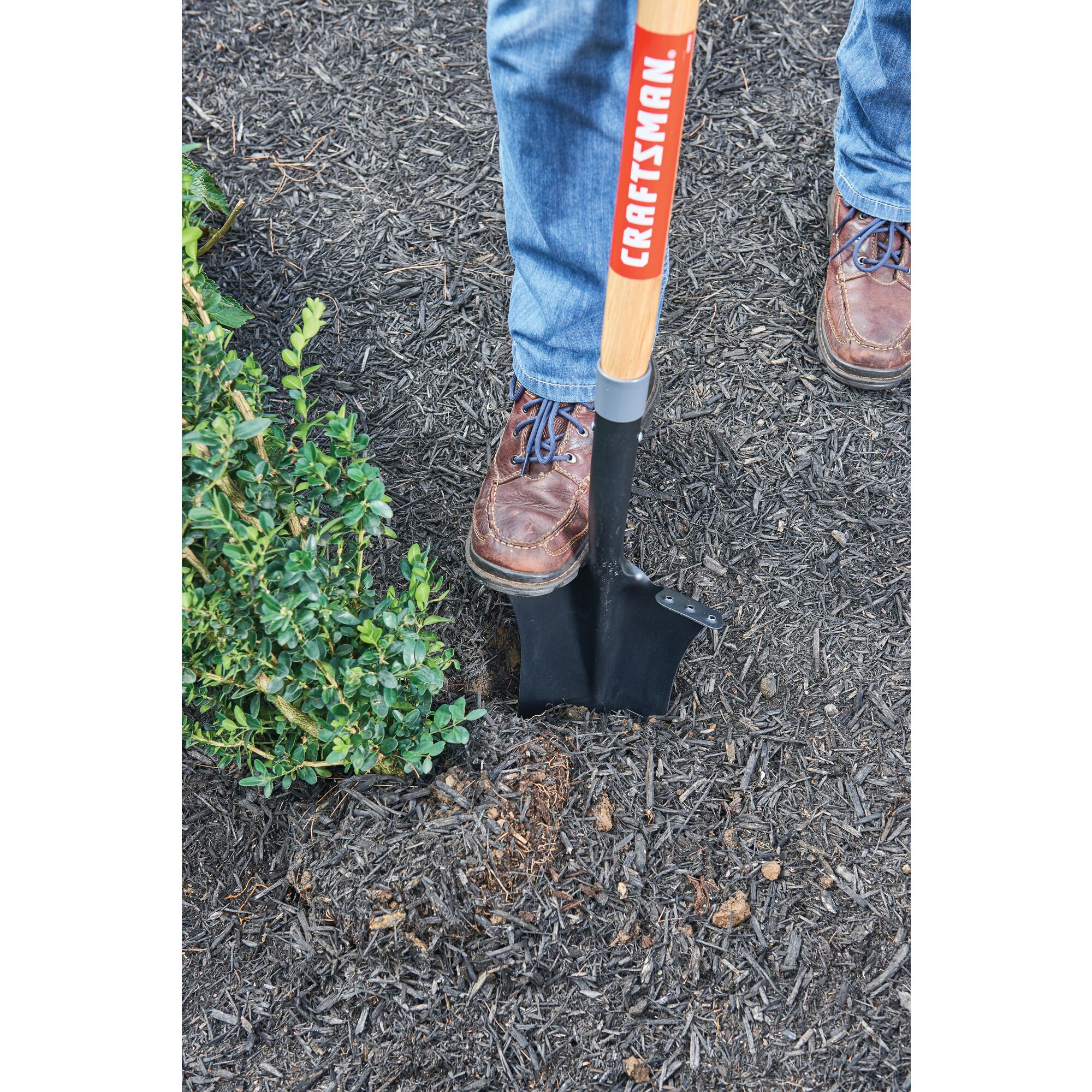 16 inch wood handle drain spade being used to dig up dirt.