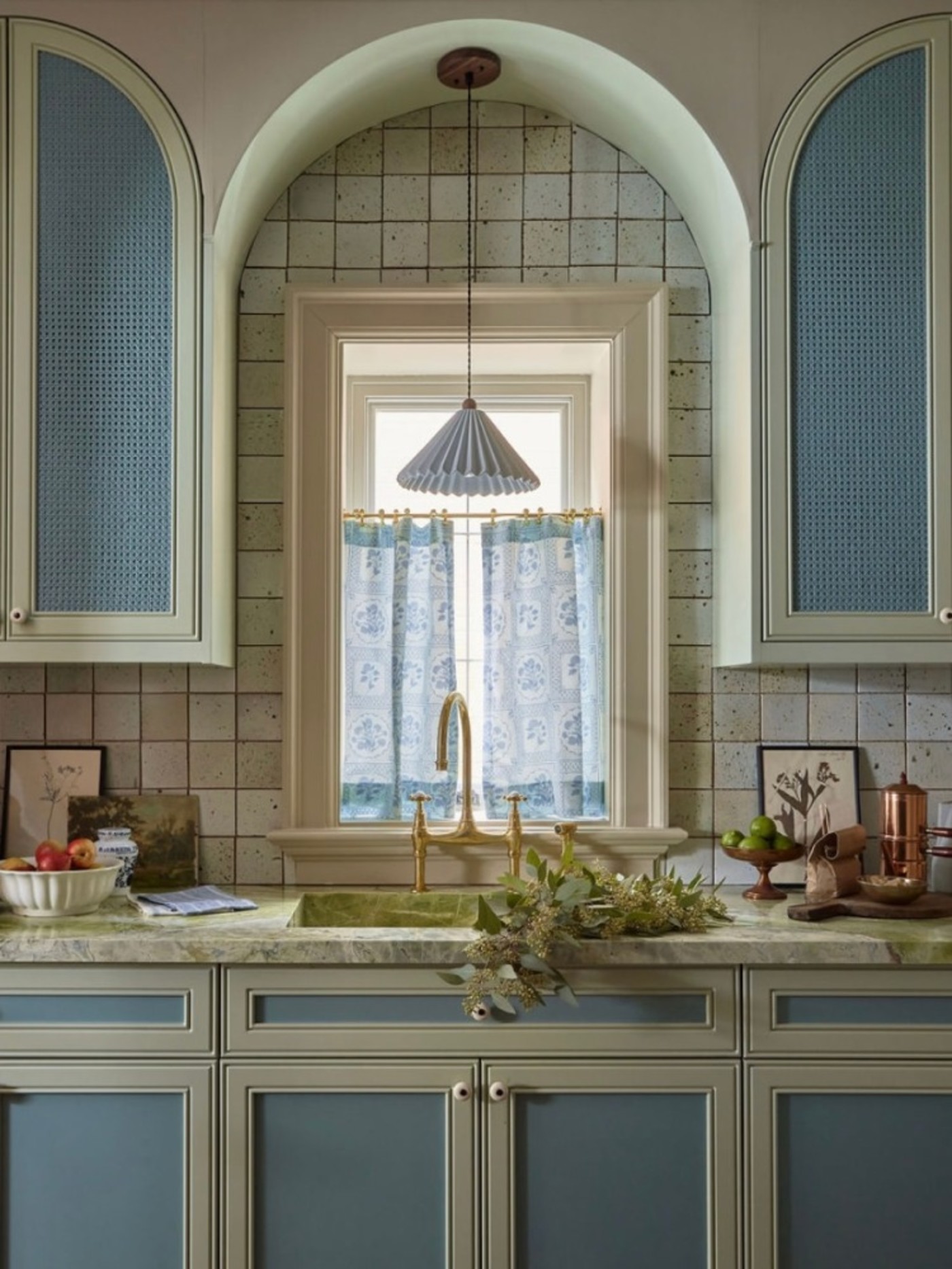 a kitchen with blue and white cabinets and a window.