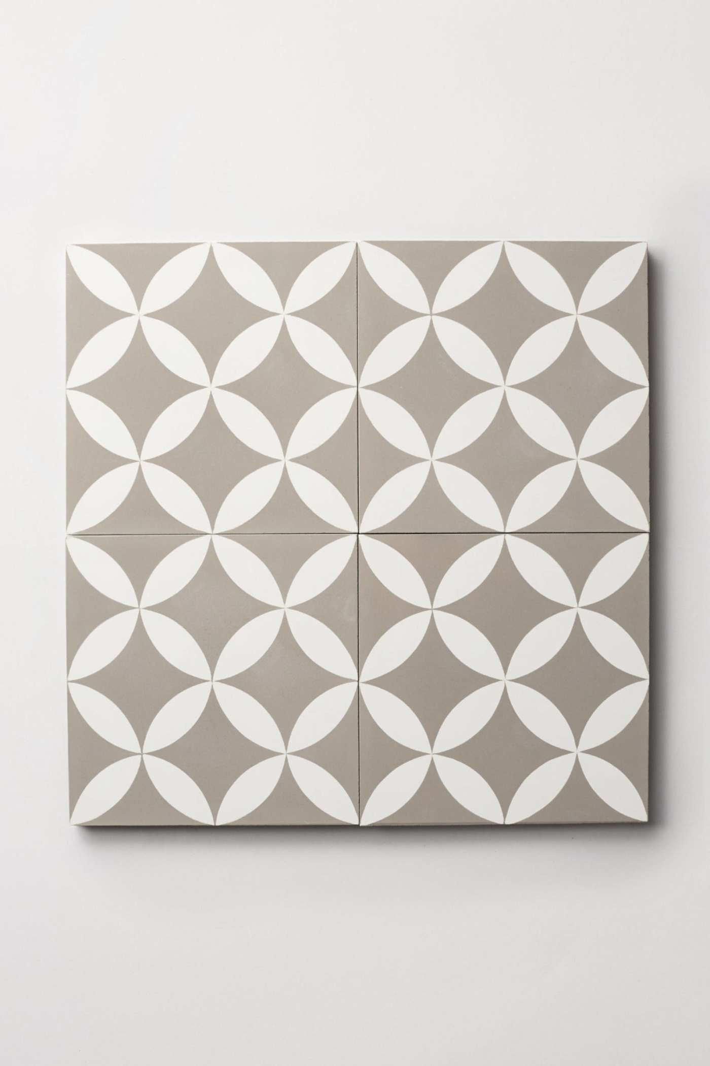 four white and grey tiles on a white surface.