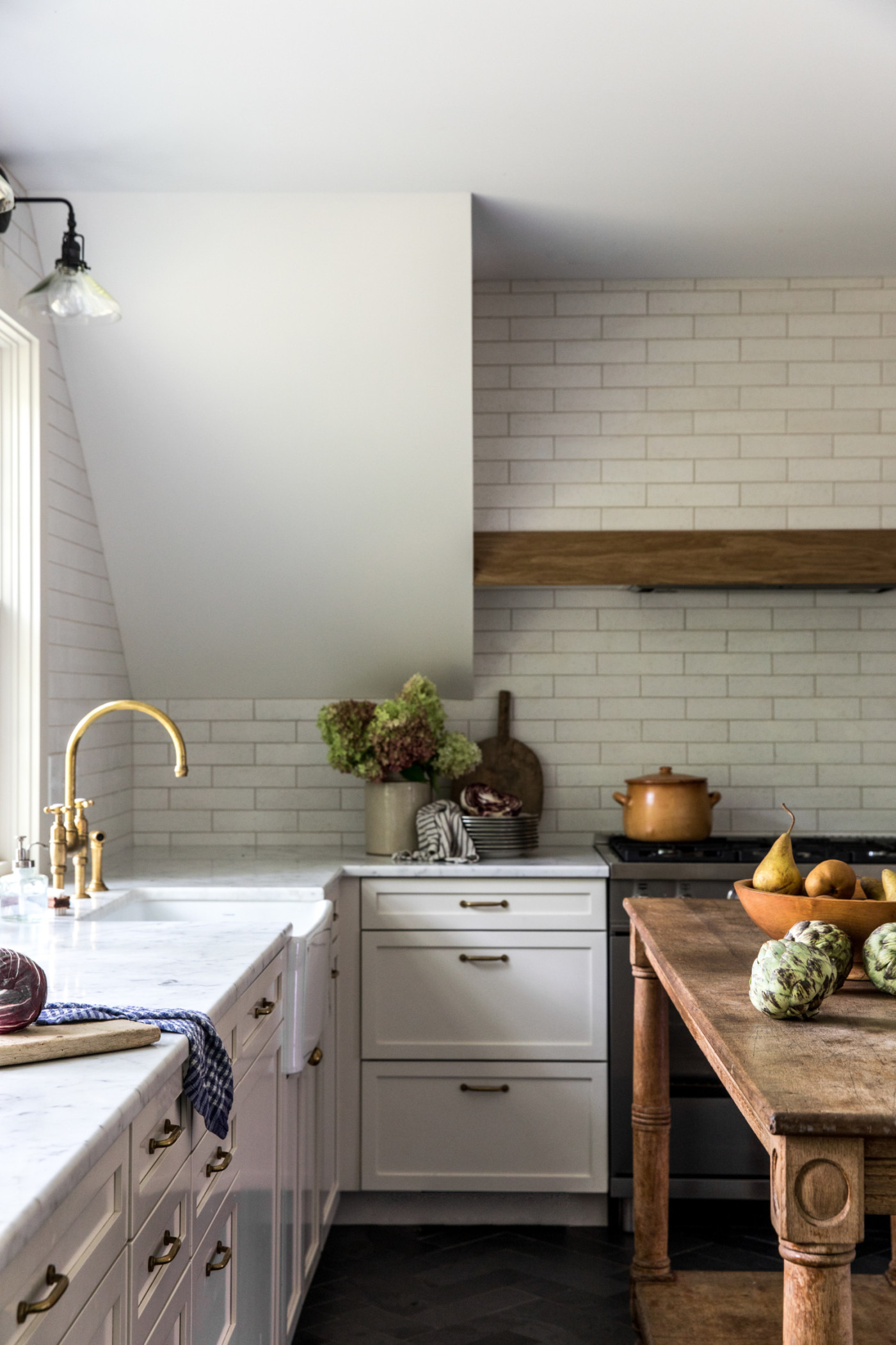 a kitchen with a sink and a bowl of fruit on a table.