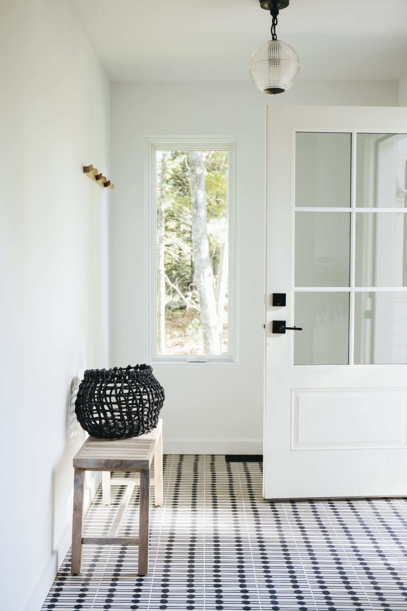 an entryway with a black and white checkered tile floor.