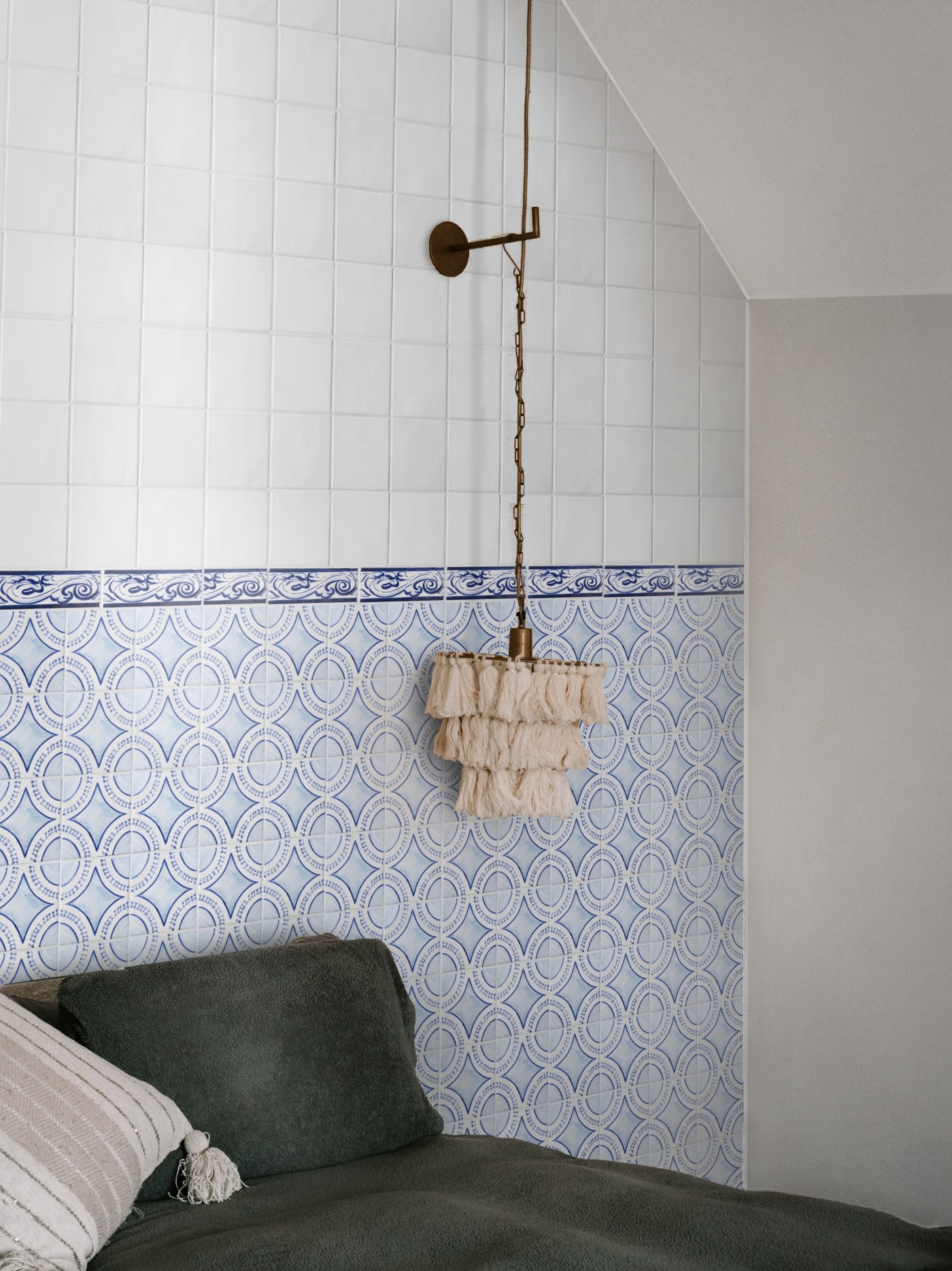 a bed in a room with blue and white tiled walls.