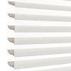 Sheer zebra roller blinds with alternating opaque and translucent horizontal bands, lowered to filter and diffuse bright daylight, shown close-up against a plain white background in soft light.