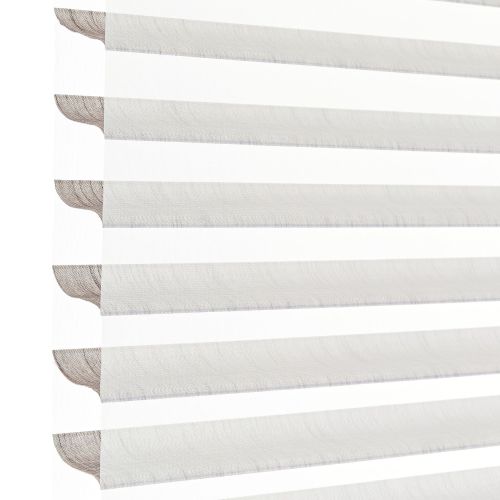 Sheer zebra roller blinds with alternating opaque and translucent horizontal bands, lowered to filter and diffuse bright daylight, shown close-up against a plain white background in soft light.