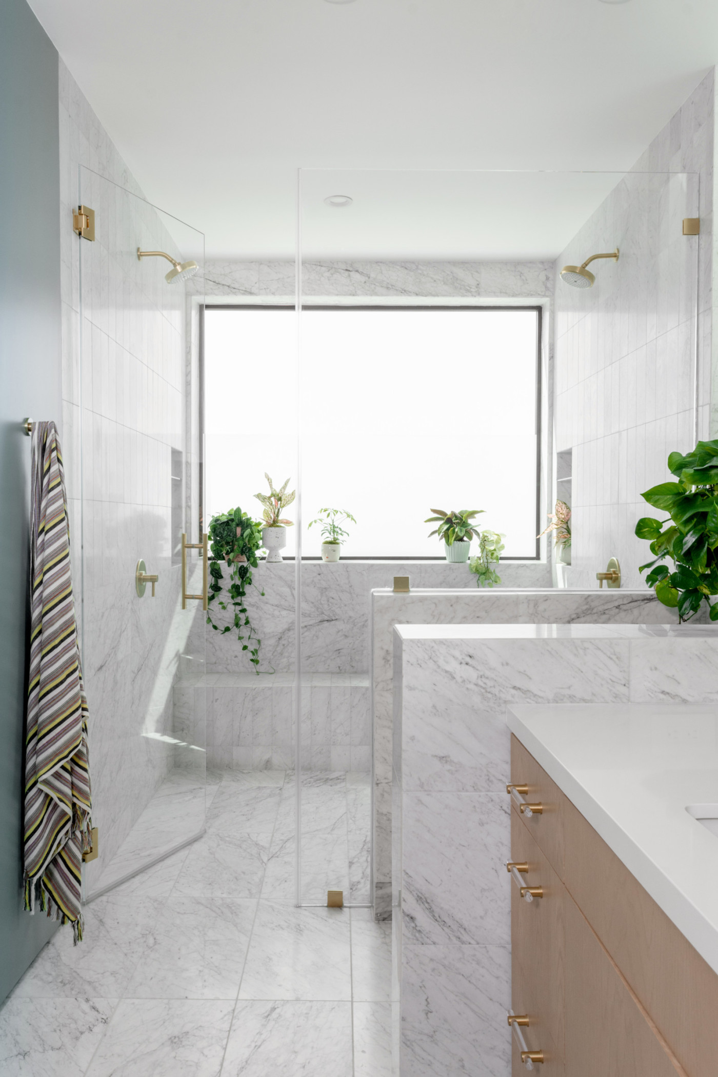 a bathroom with a large window and marble floors.