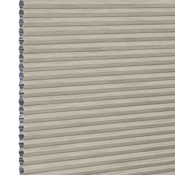 Beige honeycomb cellular window blind with pleated horizontal ribs and exposed left-edge cells — fully lowered and closed, blocking view; close-up fills frame in neutral, even lighting.