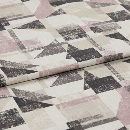Folded upholstery fabric with distressed geometric triangles and rectangles in muted pink, beige and charcoal — lying layered on a flat surface, close-up under soft studio lighting.