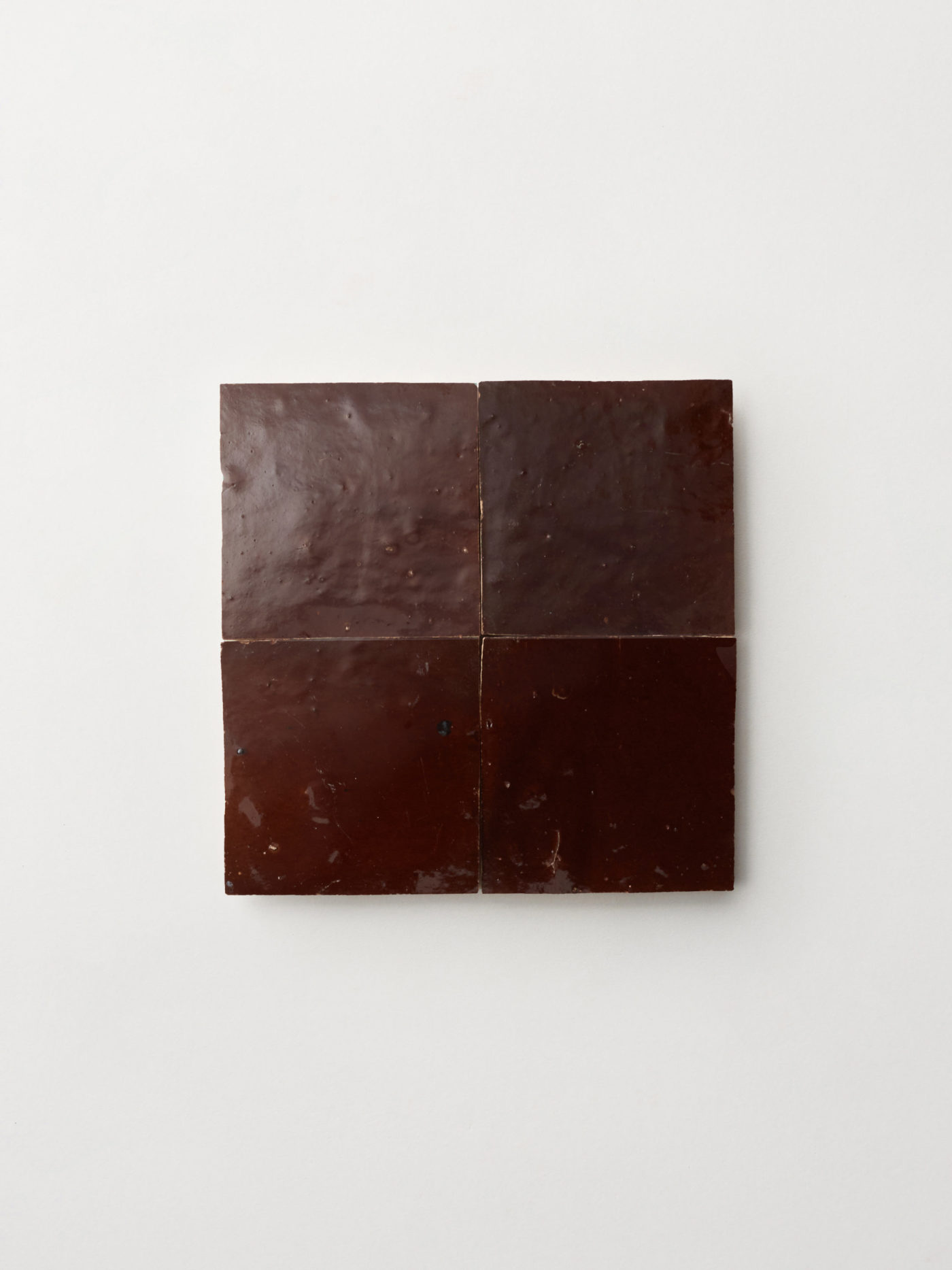 4 square brown tiles on a white surface.