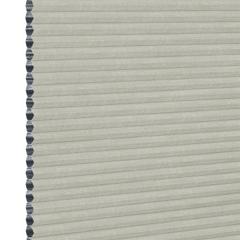 A closed light-gray cellular (honeycomb) window shade, hexagonal dark-gray cell edges visible along the left; filtering light while covering the opening; close-up view with neutral, even lighting.