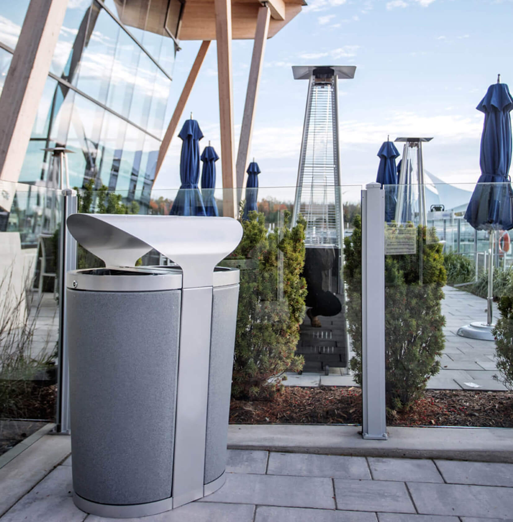 durable powder coated steel waste and recycling bin with canopy lid and durable plastic liners outside at a restaurant