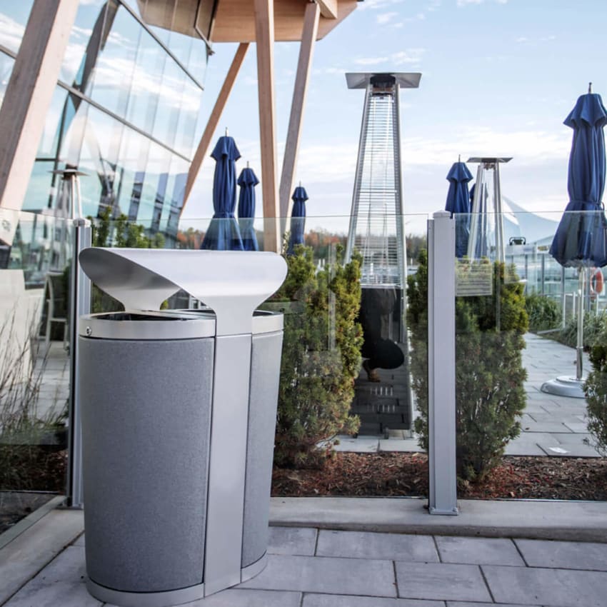 durable powder coated steel waste and recycling bin with canopy lid and durable plastic liners outside at a restaurant