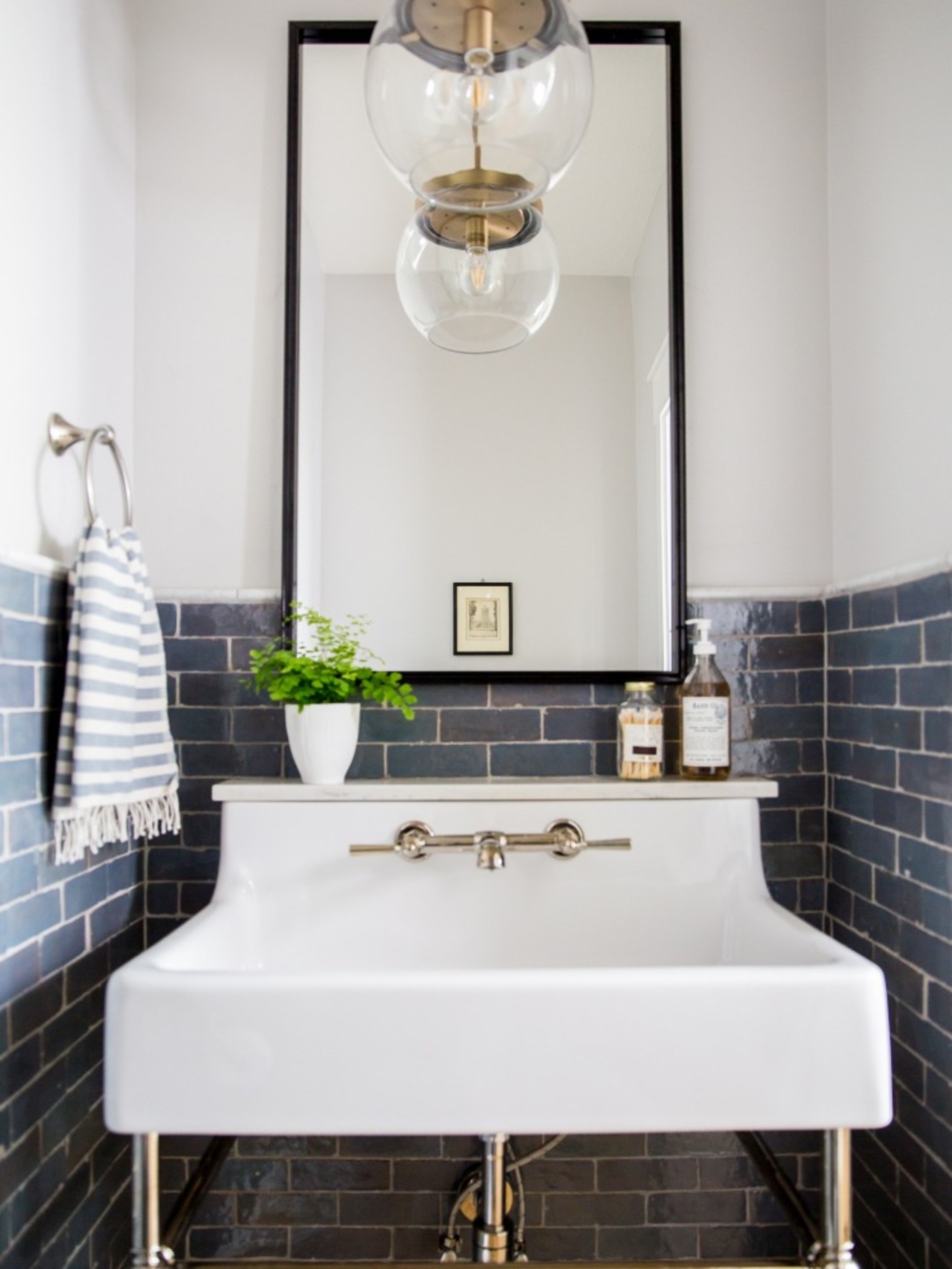 a bathroom with a blue tiled backsplash wall.