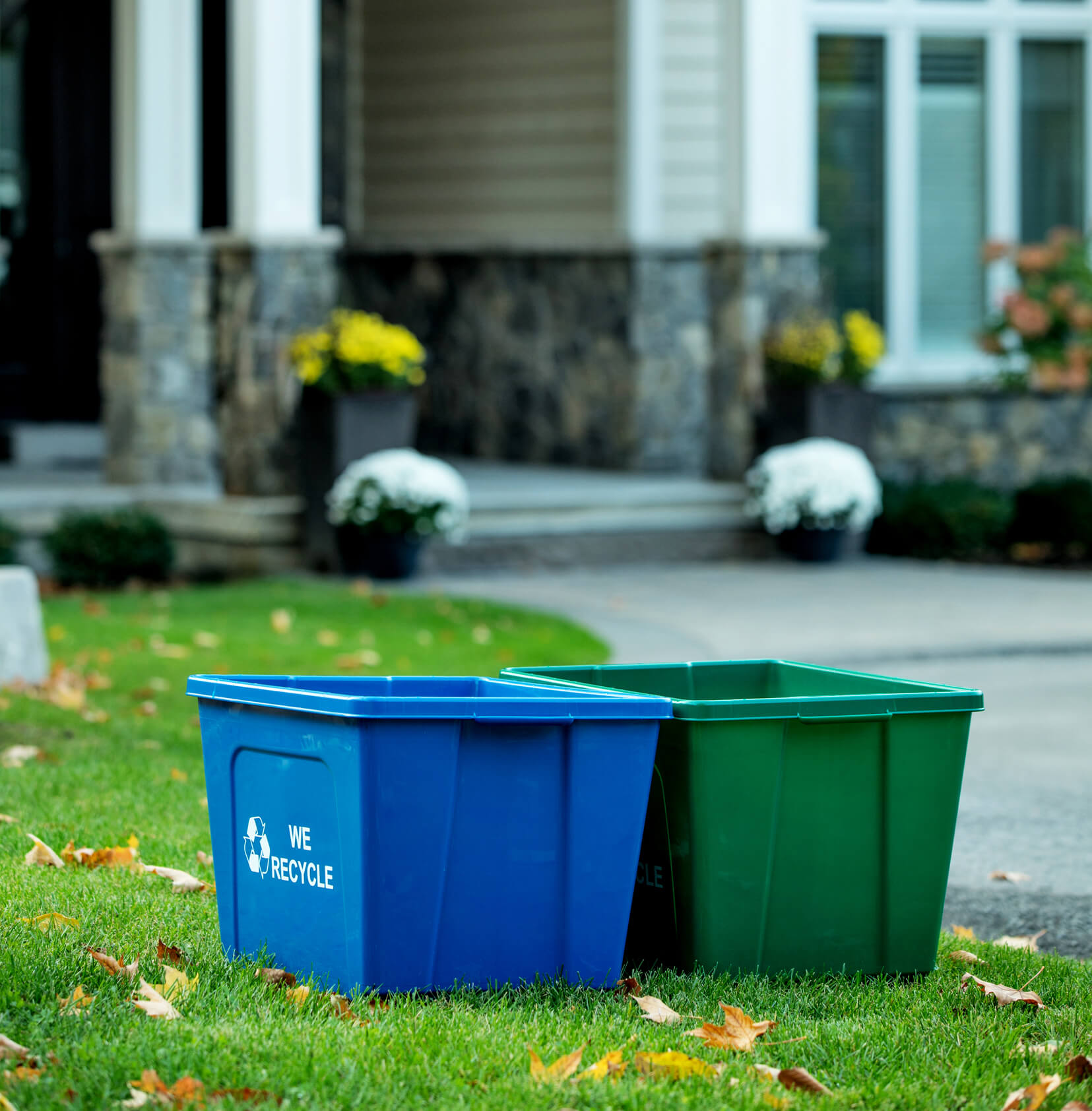 large capacity durable blue and green recycling and organics bins sitting on a residential property