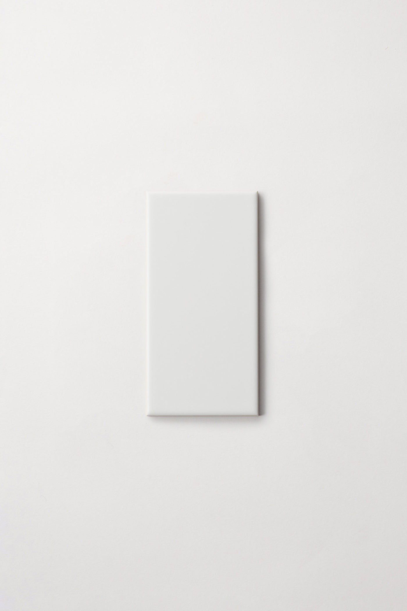 a white rectangle tile on a white surface.