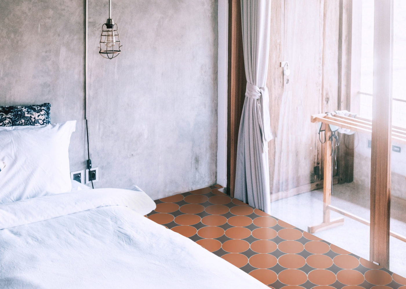 a bed in a room with a red and black tiled floor.