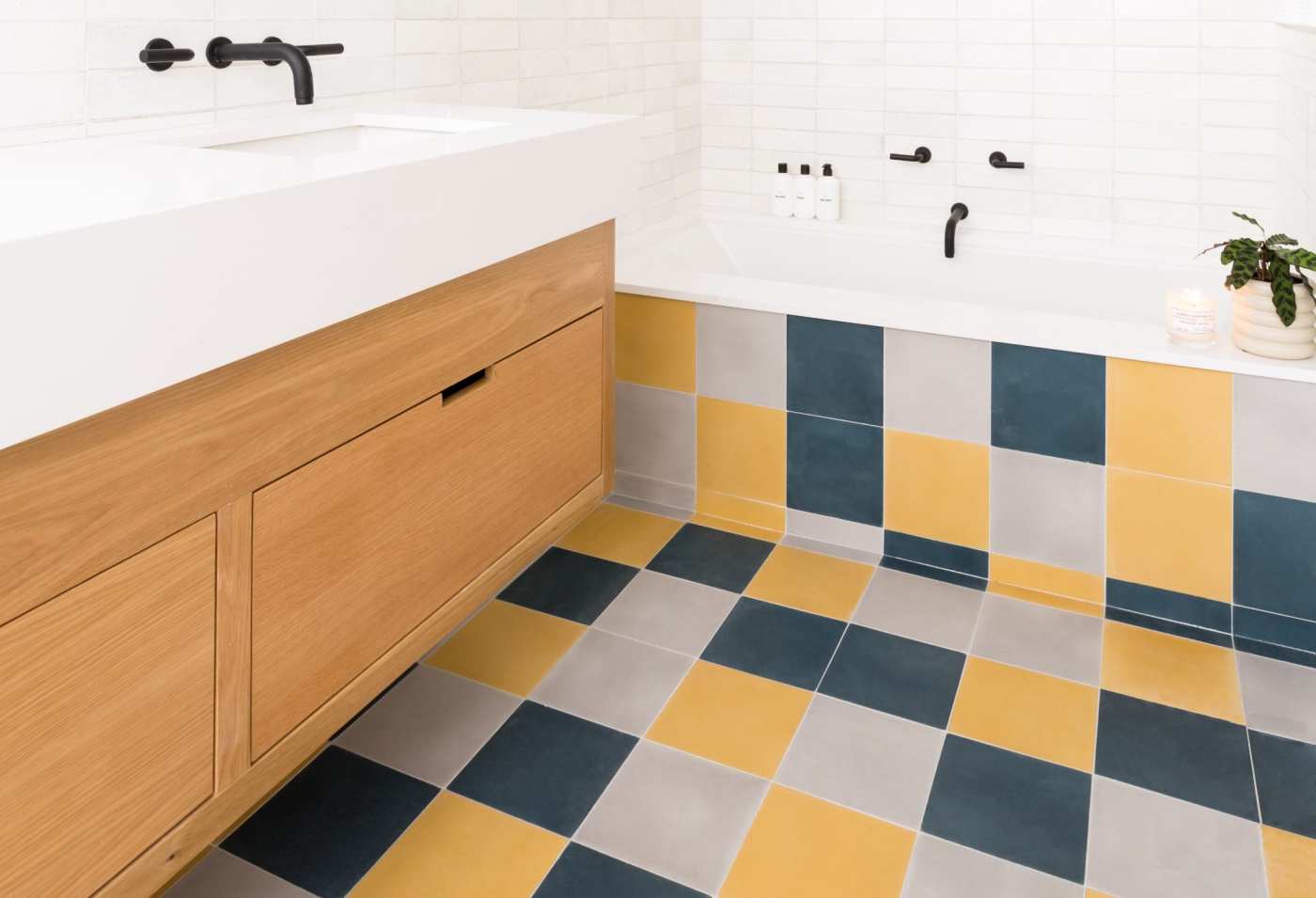 a bathroom with a yellow, grey, and blue tiled floor.