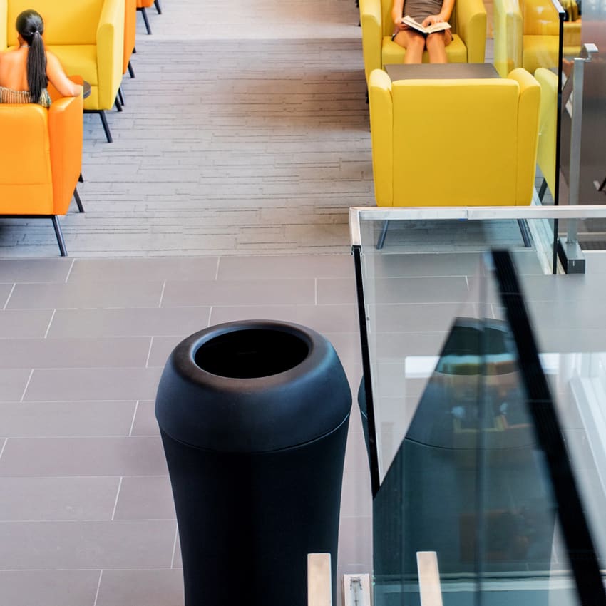 large round black waste container in a college lounge