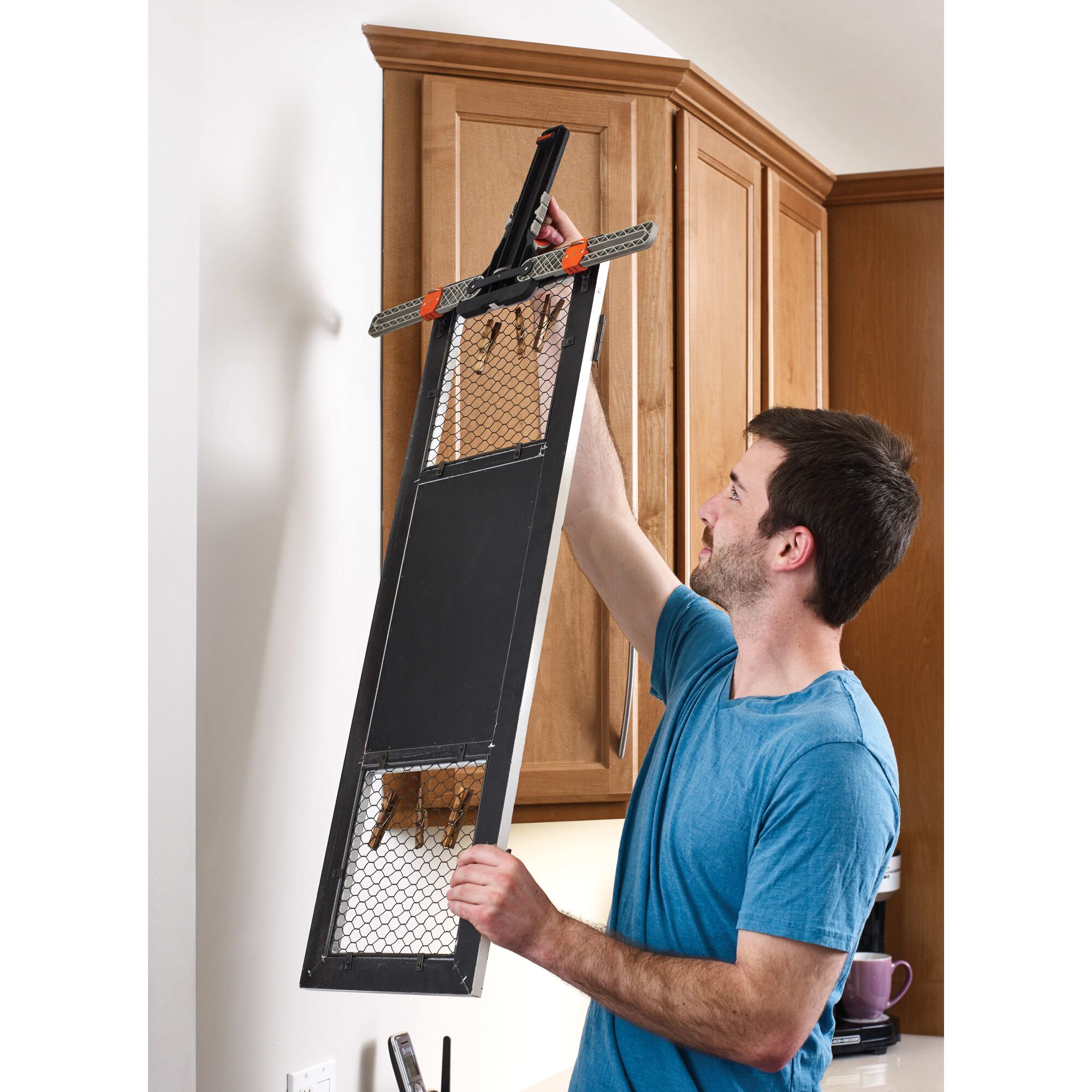 MarkIT picture hanging tool being used by a person to visualize placement of the frame.