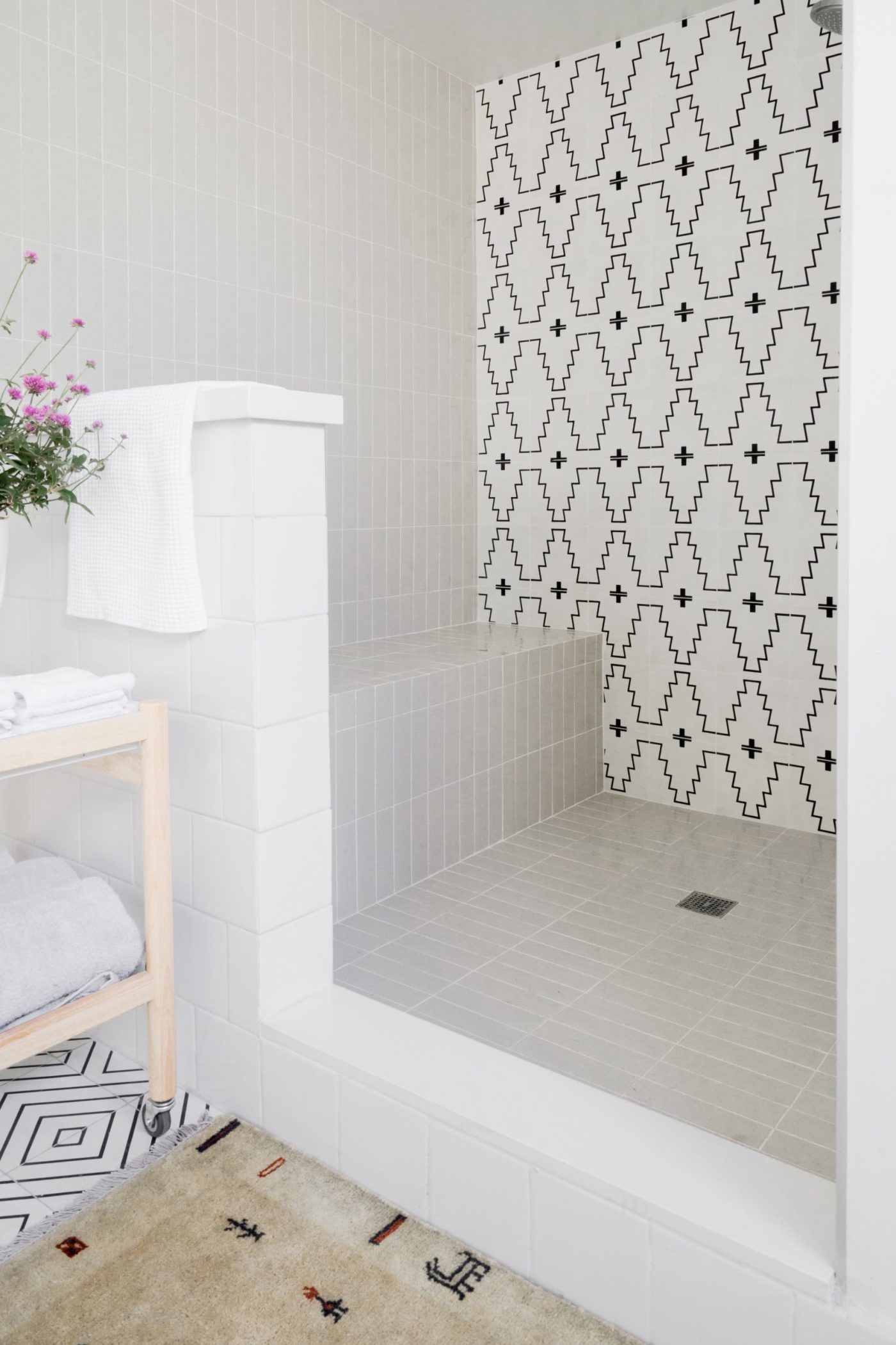 a bathroom with a black and white tiled shower.