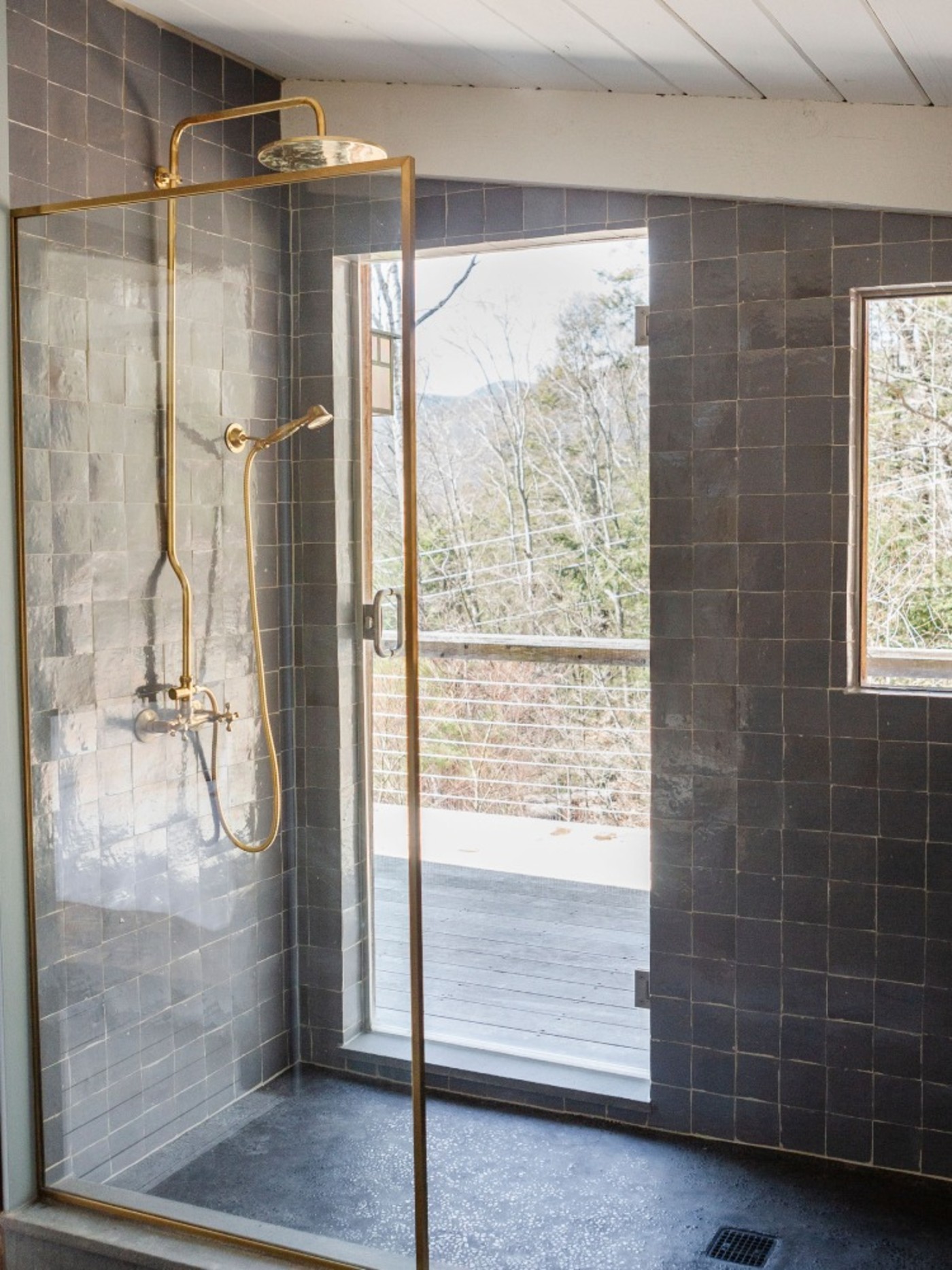 a tiled shower stall with a view of the mountains.