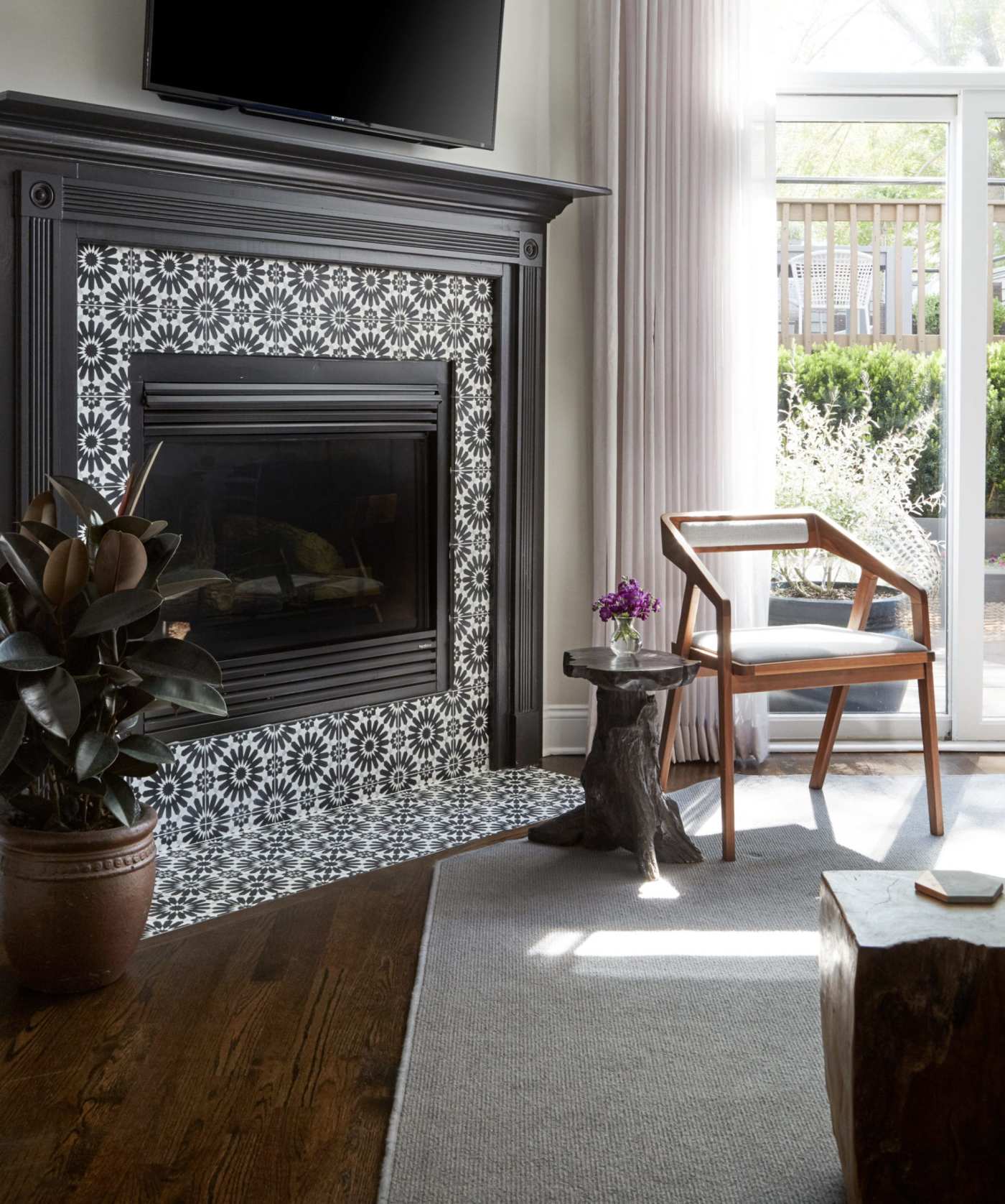 a living room with a blue and white tiled fireplace and a TV above it.