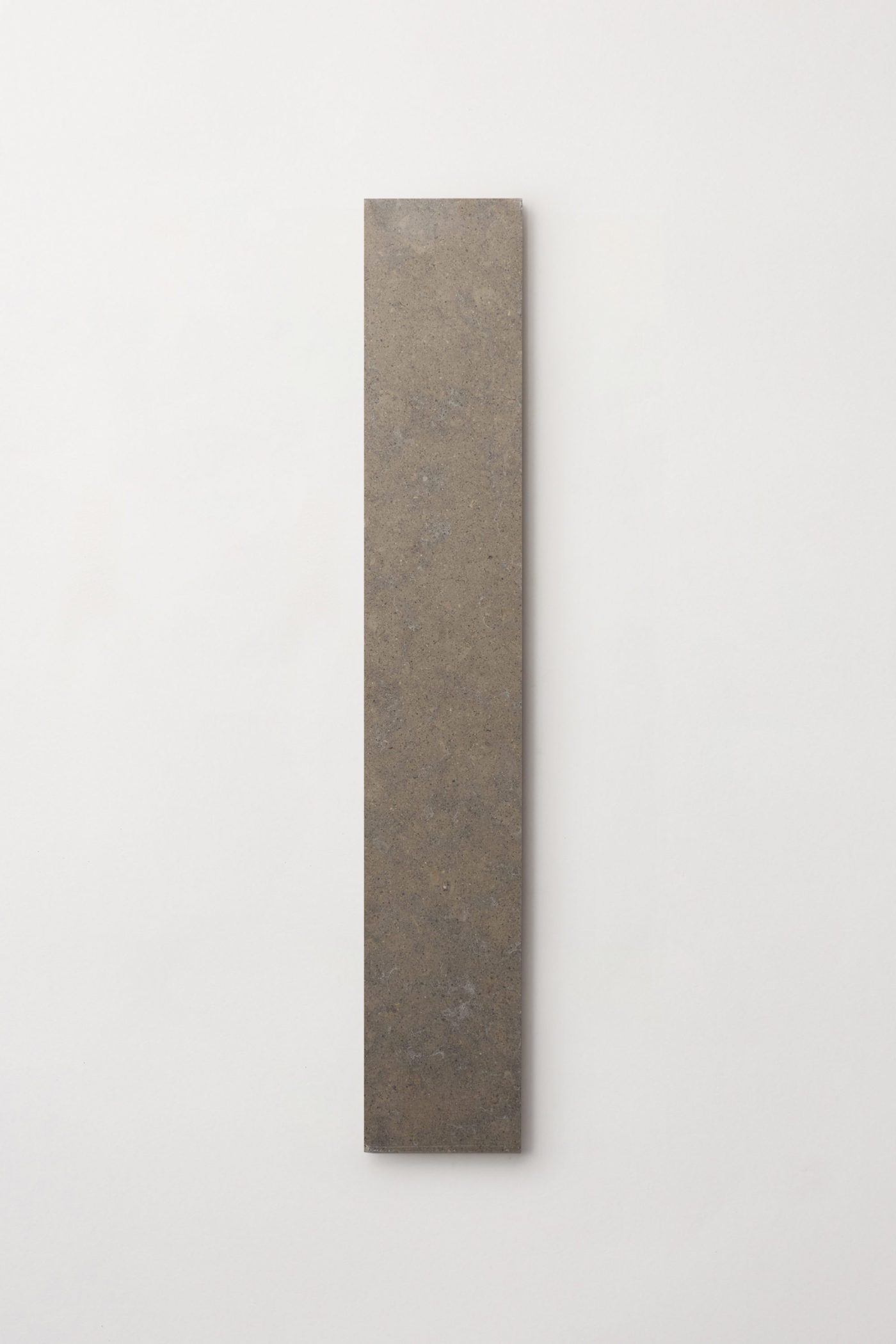 a rectangular piece of stone on a white wall.