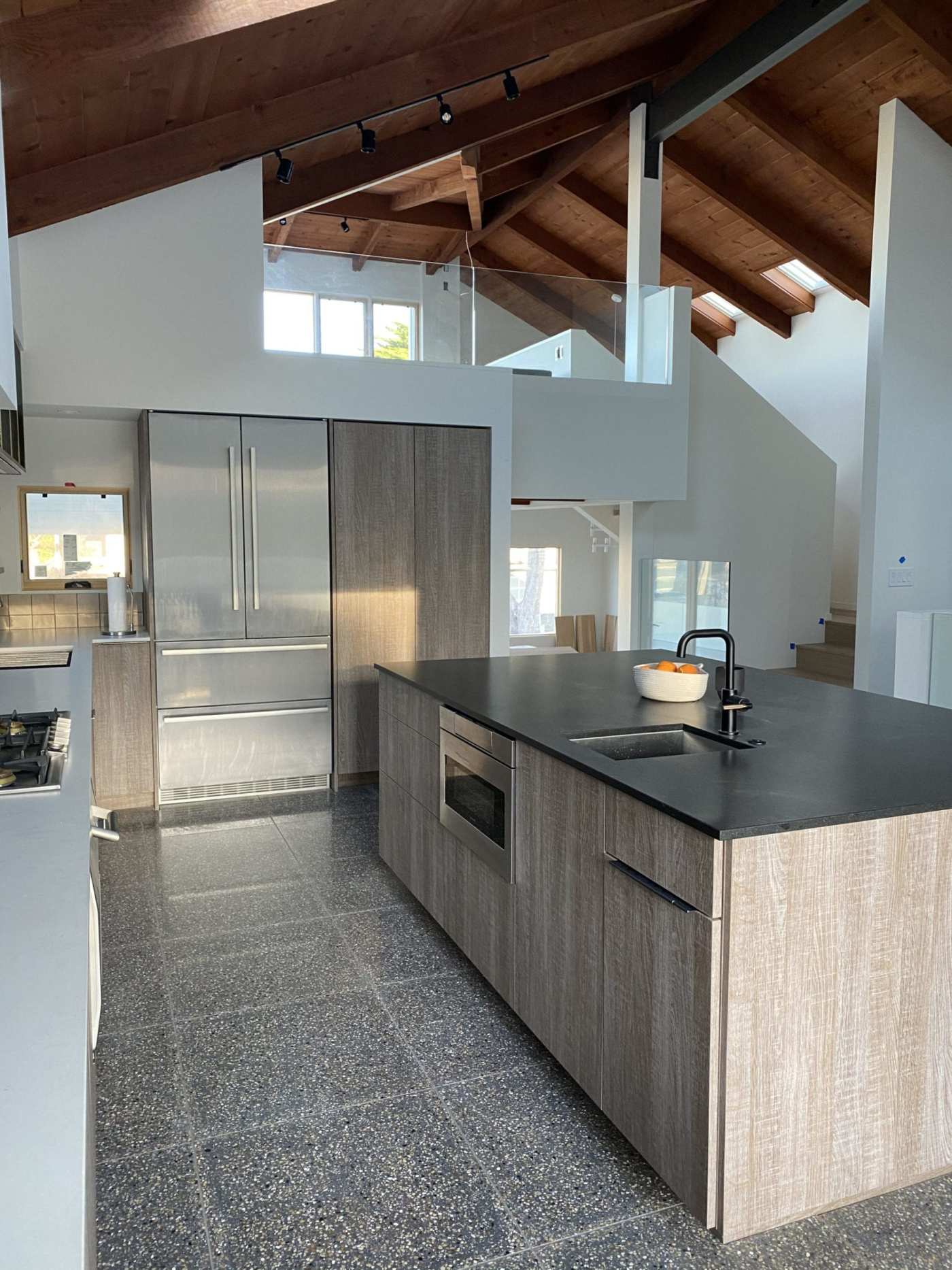 a kitchen with a large island and stainless steel appliances.