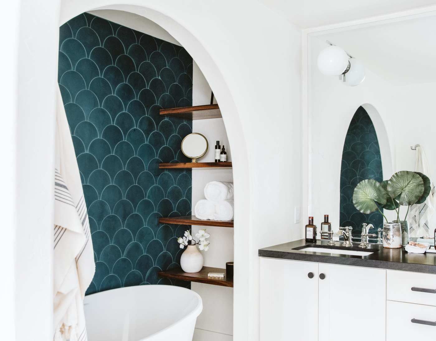 a bathroom with a white tub and a blue tiled wall.