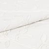 White embroidered fabric folded and overlapping, showing raised floral vine stitching and textured weave; close-up studio view with soft, even lighting emphasizing subtle shadows and fabric detail.