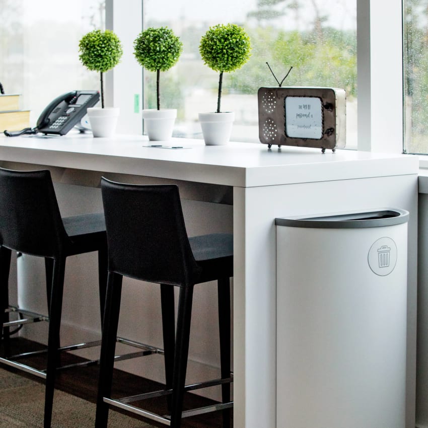 modern white metal trash container sitting in a medical office waiting area