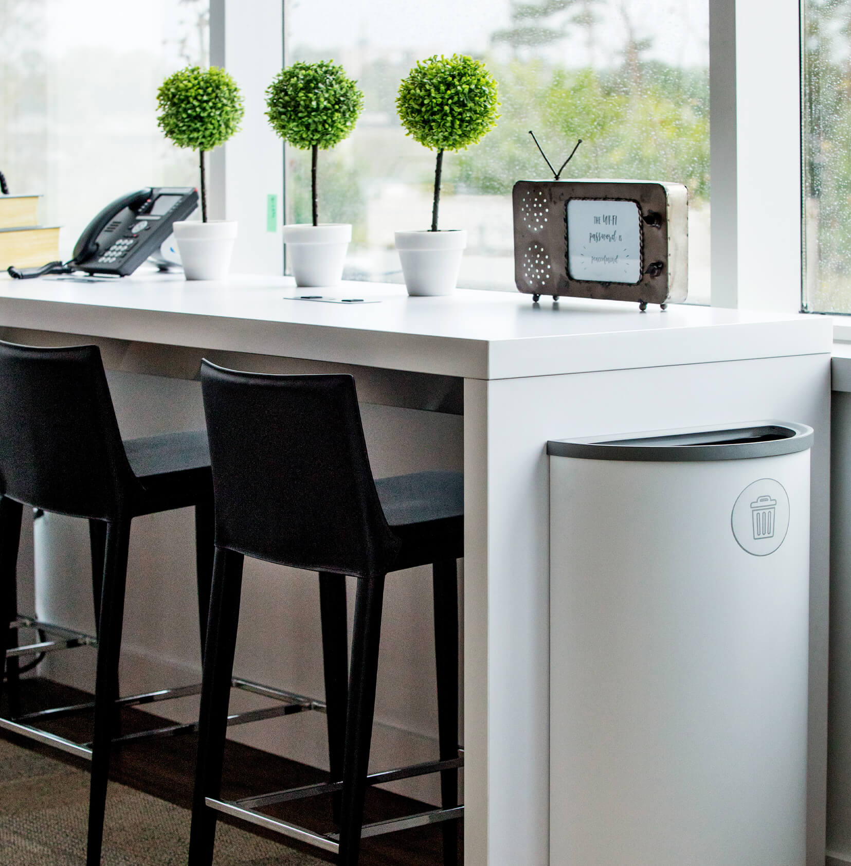 modern white metal trash container sitting in a medical office waiting area