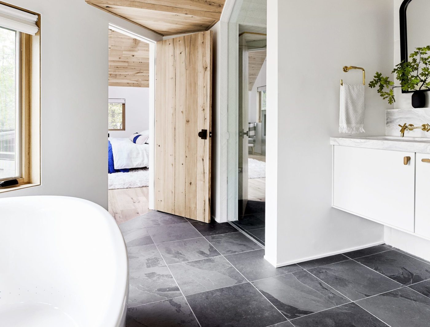 a black and white bathroom with a slate colored tile floor.